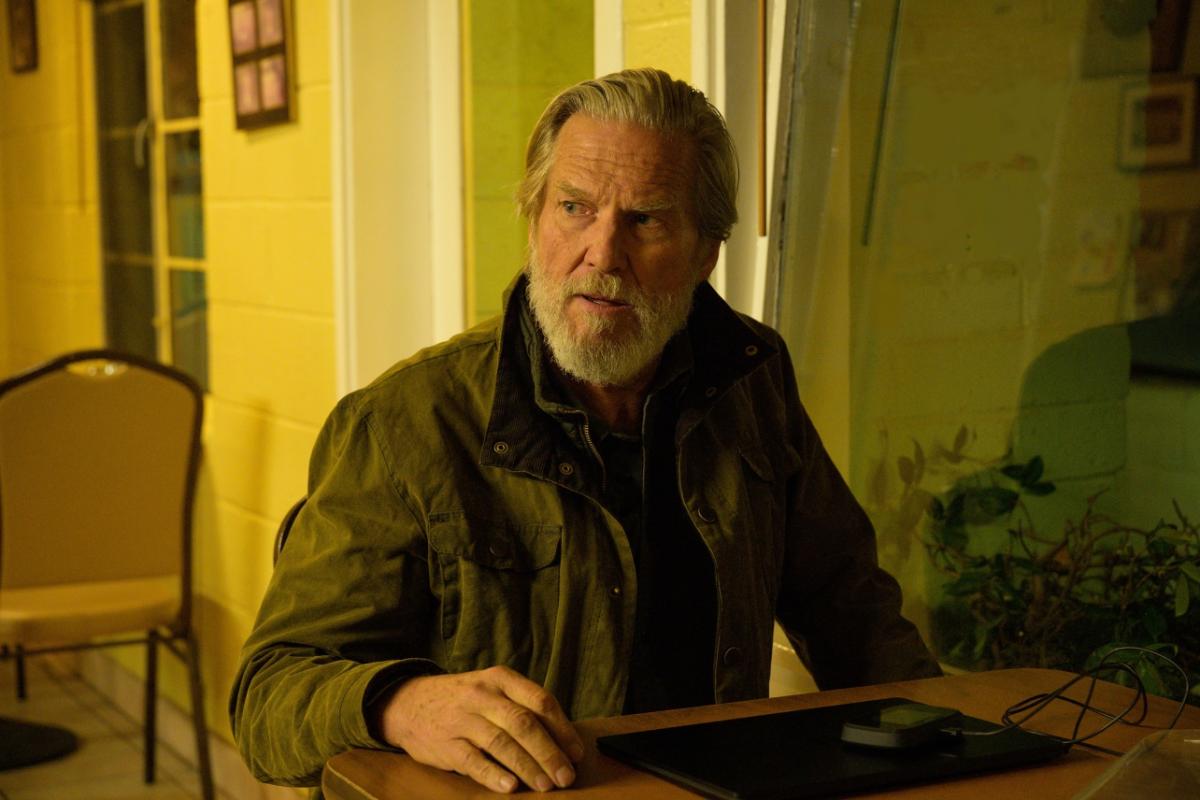 Jeff Bridges seduto al tavolo in The Old Man