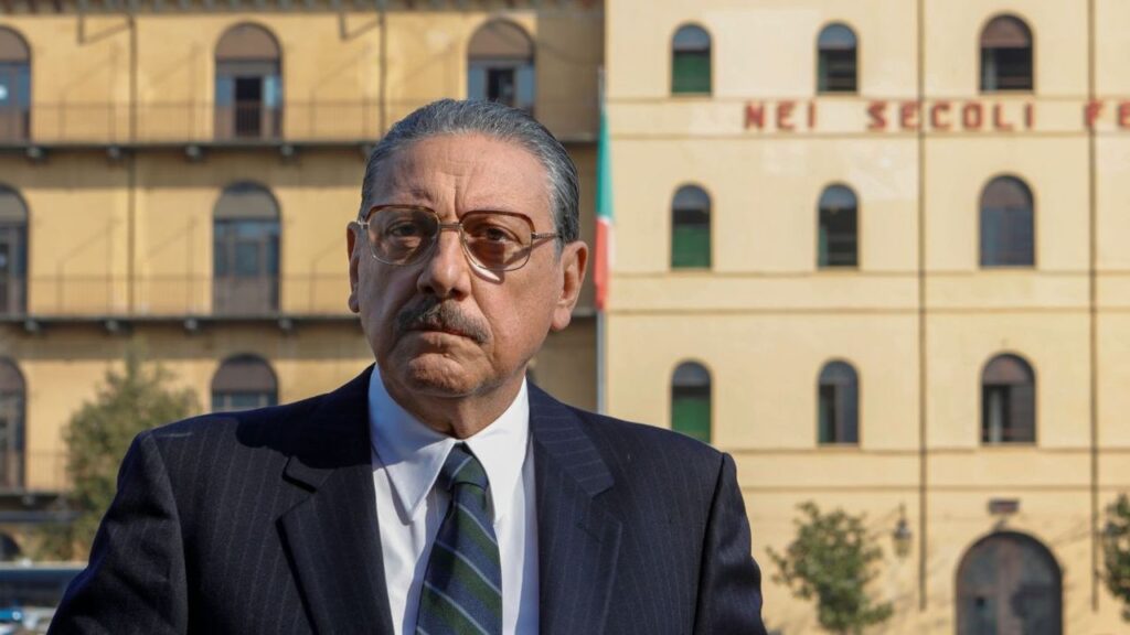 Sergio Castellitto posa davanti a una caserma col motto dei Carabinieri