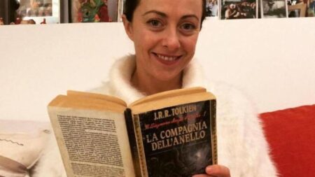 Fotografia di Giorgia Meloni che regge tra le mani una copia de Il Signore degli Anelli