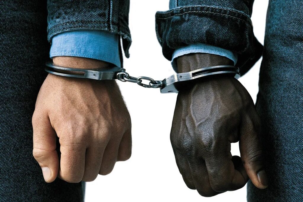Le mani di un nero e un bianco ammanettate insieme - foto di Oliviero Toscani