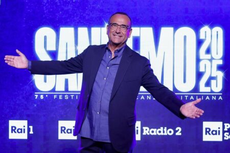 Carlo Conti davanti al logo di Sanremo 2025