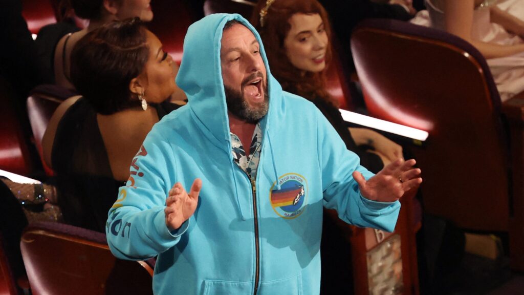 Oscar 2025, Adam Sandler in felpa e pantaloncini, urla nelle orecchie a Chalamet (VIDEO) Adam Sandler in felpa agli Oscar 2025
