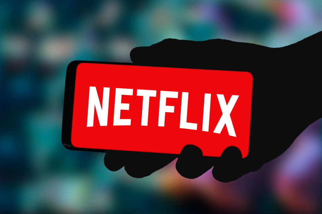 Netflix risponde a Rian Johnson sulla questione sale: “Possono convivere con lo streaming” Cellulare con logo Netflix