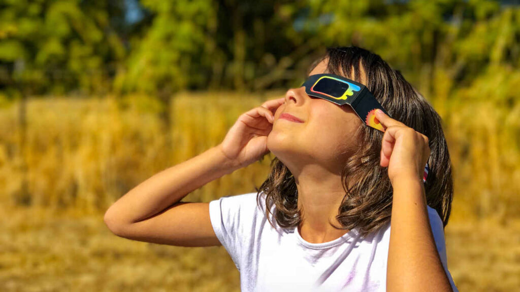 Perché guardare l’eclissi solare fa male agli occhi senza gli occhiali adatti: ecco quali usare Una bambina con gli occhiali specifici per osservare le eclissi solari